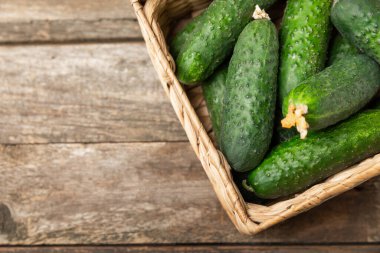 Ahşap arka planda salatalık. Arka planda bir parça salatalık. Taze organik yeşil salatalık turşusu. Vejetaryen. Salata malzemesi. Çiftlik sebzeleri. Sebzeleri bıçakla kes. Mesaj için yer var. Boşluğu kopyala