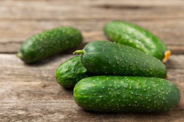 Ahşap arka planda salatalık. Arka planda bir parça salatalık. Taze organik yeşil salatalık turşusu. Vejetaryen. Salata malzemesi. Çiftlik sebzeleri. Sebzeleri bıçakla kes. Mesaj için yer var. Boşluğu kopyala