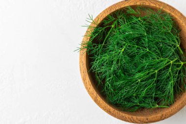 Ahşap arka planda Dill. Taze organik sebzeler. Dill çiftliği. Dereotu yapraklarını kes. Bahar genç deresi sürüsü. Vitaminler. İplik. Aromatik mutfak baharatı. Mesaj için yer. Boşluğu kopyala