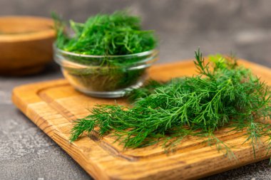 Ahşap arka planda Dill. Taze organik sebzeler. Dill çiftliği. Dereotu yapraklarını kes. Bahar genç deresi sürüsü. Vitaminler. İplik. Aromatik mutfak baharatı. Mesaj için yer. Boşluğu kopyala
