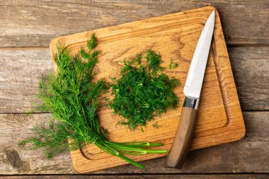 Ahşap arka planda Dill. Taze organik sebzeler. Dill çiftliği. Dereotu yapraklarını kes. Bahar genç deresi sürüsü. Vitaminler. İplik. Aromatik mutfak baharatı. Mesaj için yer. Boşluğu kopyala