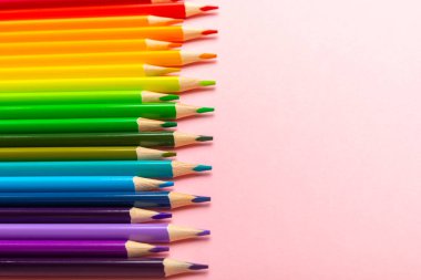 Renkli arka planda renkli kalemler. Boyama için ekipman. Yaratıcılık için kırtasiye malzemesi. Okula dönüyorum. Flatlay. Çocukların Yaratıcılığı ve Eğitimi. Rainbow.Mesaj için yer var. Boşluğu kopyala.