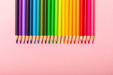 Renkli arka planda renkli kalemler. Boyama için ekipman. Yaratıcılık için kırtasiye malzemesi. Okula dönüyorum. Flatlay. Çocukların Yaratıcılığı ve Eğitimi. Rainbow.Mesaj için yer var. Boşluğu kopyala.