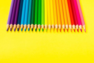 Renkli arka planda renkli kalemler. Boyama için ekipman. Yaratıcılık için kırtasiye malzemesi. Okula dönüyorum. Flatlay. Çocukların Yaratıcılığı ve Eğitimi. Rainbow.Mesaj için yer var. Boşluğu kopyala.