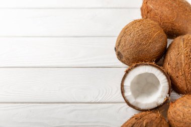 Tahta arka planda taze hindistan cevizi ve dilimler var. Hindistan cevizi gevreği. Vejetaryen. Tropik fındık, meyve. Mesaj için yer. Boşluğu kopyala.