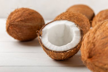 Tahta arka planda taze hindistan cevizi ve dilimler var. Hindistan cevizi gevreği. Vejetaryen. Tropik fındık, meyve. Mesaj için yer. Boşluğu kopyala.