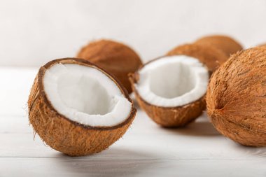 Tahta arka planda taze hindistan cevizi ve dilimler var. Hindistan cevizi gevreği. Vejetaryen. Tropik fındık, meyve. Mesaj için yer. Boşluğu kopyala.