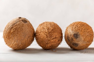 Tahta arka planda taze hindistan cevizi ve dilimler var. Hindistan cevizi gevreği. Vejetaryen. Tropik fındık, meyve. Mesaj için yer. Boşluğu kopyala.