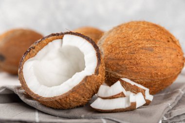 Tahta arka planda taze hindistan cevizi ve dilimler var. Hindistan cevizi gevreği. Vejetaryen. Tropik fındık, meyve. Mesaj için yer. Boşluğu kopyala.