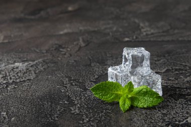 Arka planda nane ve buz var. Yeşil taze nane ve buz küpü. Nane yaprağı, buz küpü ve soğuk içecek için su damlası. Üst Manzara. Mesaj için yer var. Boşluğu kopyala.