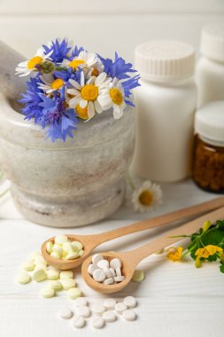 Ahşap zemin üzerinde alternatif ilaç bitkisel kapsül organik ilaç. Bitki ve tablet çeşitleri, vitaminler ve diyet takviyeleri. Sağlıklı yaşam için tıbbi ve şifalı bitkiler.