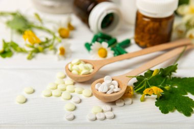 Ahşap zemin üzerinde alternatif ilaç bitkisel kapsül organik ilaç. Bitki ve tablet çeşitleri, vitaminler ve diyet takviyeleri. Sağlıklı yaşam için tıbbi ve şifalı bitkiler.