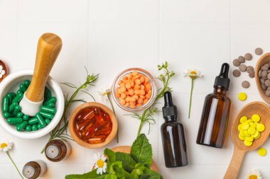 Ahşap zemin üzerinde alternatif ilaç bitkisel kapsül organik ilaç. Bitki ve tablet çeşitleri, vitaminler ve diyet takviyeleri. Sağlıklı yaşam için tıbbi ve şifalı bitkiler.