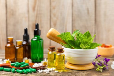 Ahşap zemin üzerinde alternatif ilaç bitkisel kapsül organik ilaç. Bitki ve tablet çeşitleri, vitaminler ve diyet takviyeleri. Sağlıklı yaşam için tıbbi ve şifalı bitkiler.