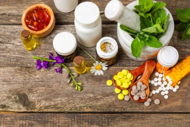 Ahşap zemin üzerinde alternatif ilaç bitkisel kapsül organik ilaç. Bitki ve tablet çeşitleri, vitaminler ve diyet takviyeleri. Sağlıklı yaşam için tıbbi ve şifalı bitkiler.