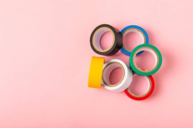 Parlak renkli arka plandaki bant yalıtılıyor. Farklı renkte izolasyon bantları. Yalıtım bandı. İnşaat aletleri. Elektrikçi aletleri. Bir parça koli bandı. Metin için boşluk. Boşluğu kopyala.