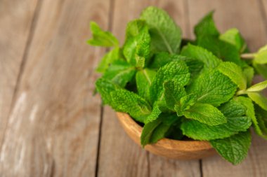 Naneli. Ahşap arka planda taze organik nane yaprakları. Nane yaprakları. Nane şekeri. Yakın plan. Mesaj için yer var. Boşluğu kopyala.