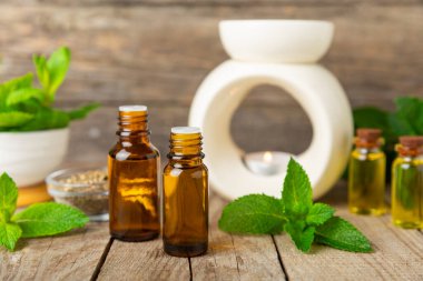 Ahşap bir arka planda esaslı bir nane şekeri. Naneli esaslı yağ ve taze nane yaprakları. Bir şişe aromaterapi yağı. Nane özütü. Doğal kozmetik konsepti, spa bakımı. Boşluğu kopyala