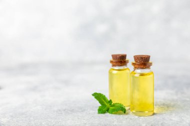Ahşap bir arka planda esaslı bir nane şekeri. Naneli esaslı yağ ve taze nane yaprakları. Bir şişe aromaterapi yağı. Nane özütü. Doğal kozmetik konsepti, spa bakımı. Boşluğu kopyala