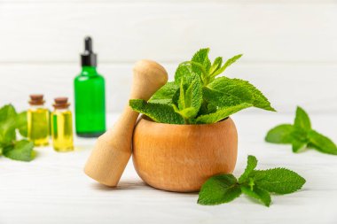 Ahşap zemin üzerinde havan ve kabuk ile taze nane. Melissa gider. Şifalı bitkiler, ilaç için havanda yeşil nane yaprakları. Mesaj için alan. Boşluğu kopyala.