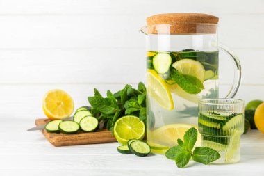 Salatalık suyu, limon, nane ve ahşap bir masada. İçme bardağında dilimlenmiş salatalık ile karıştırılmış su. Tonik ferahlatıcı bir içecek. Salatalık limonata. Doğal soğutma içeceği. Boşluğu kopyala.
