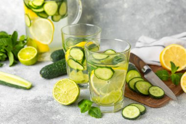 Salatalık suyu, limon, nane ve ahşap bir masada. İçme bardağında dilimlenmiş salatalık ile karıştırılmış su. Tonik ferahlatıcı bir içecek. Salatalık limonata. Doğal soğutma içeceği. Boşluğu kopyala.