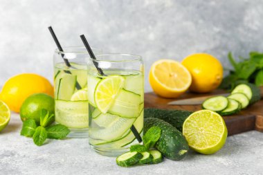 Salatalık suyu, limon, nane ve ahşap bir masada. İçme bardağında dilimlenmiş salatalık ile karıştırılmış su. Tonik ferahlatıcı bir içecek. Salatalık limonata. Doğal soğutma içeceği. Boşluğu kopyala.