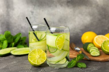 Salatalık suyu, limon, nane ve ahşap bir masada. İçme bardağında dilimlenmiş salatalık ile karıştırılmış su. Tonik ferahlatıcı bir içecek. Salatalık limonata. Doğal soğutma içeceği. Boşluğu kopyala.