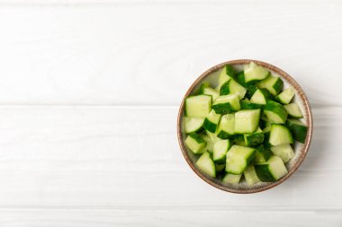 Ahşap arka planda salatalık. Arka planda bir parça salatalık. Taze organik yeşil salatalık turşusu. Vejetaryen. Salata malzemesi. Çiftlik sebzeleri. Sebzeleri bıçakla kes. Mesaj için yer var. Boşluğu kopyala