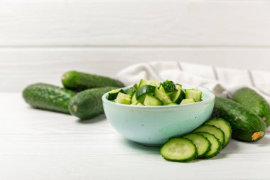 Ahşap arka planda salatalık. Arka planda bir parça salatalık. Taze organik yeşil salatalık turşusu. Vejetaryen. Salata malzemesi. Çiftlik sebzeleri. Sebzeleri bıçakla kes. Mesaj için yer var. Boşluğu kopyala