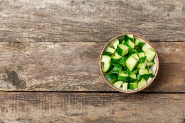 Ahşap arka planda salatalık. Arka planda bir parça salatalık. Taze organik yeşil salatalık turşusu. Vejetaryen. Salata malzemesi. Çiftlik sebzeleri. Sebzeleri bıçakla kes. Mesaj için yer var. Boşluğu kopyala
