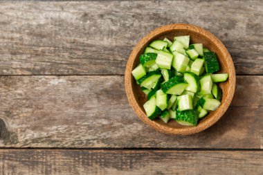 Ahşap arka planda salatalık. Arka planda bir parça salatalık. Taze organik yeşil salatalık turşusu. Vejetaryen. Salata malzemesi. Çiftlik sebzeleri. Sebzeleri bıçakla kes. Mesaj için yer var. Boşluğu kopyala