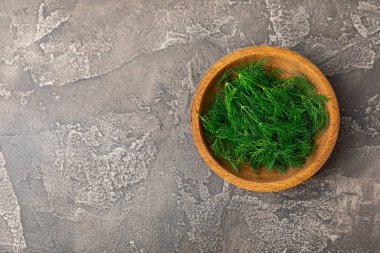 Ahşap arka planda Dill. Taze organik sebzeler. Dill çiftliği. Dereotu yapraklarını kes. Bahar genç deresi sürüsü. Vitaminler. İplik. Aromatik mutfak baharatı. Mesaj için yer. Boşluğu kopyala