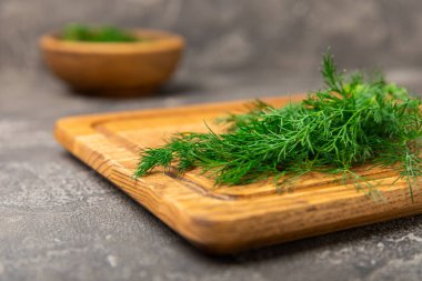 Ahşap arka planda Dill. Taze organik sebzeler. Dill çiftliği. Dereotu yapraklarını kes. Bahar genç deresi sürüsü. Vitaminler. İplik. Aromatik mutfak baharatı. Mesaj için yer. Boşluğu kopyala