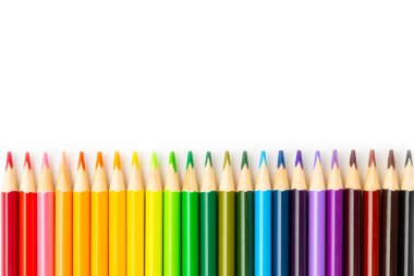 Beyaz arkaplanda izole edilmiş renkli kalemler. Boyama için ekipman. Yaratıcılık için kırtasiye malzemesi. Okula dönüyorum. Flatlay. Çocukların Yaratıcılığı ve Eğitimi. Gökkuşağı.