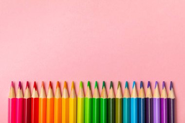 Renkli arka planda renkli kalemler. Boyama için ekipman. Yaratıcılık için kırtasiye malzemesi. Okula dönüyorum. Flatlay. Çocukların Yaratıcılığı ve Eğitimi. Rainbow.Mesaj için yer var. Boşluğu kopyala.