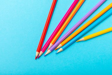 Renkli arka planda renkli kalemler. Boyama için ekipman. Yaratıcılık için kırtasiye malzemesi. Okula dönüyorum. Flatlay. Çocukların Yaratıcılığı ve Eğitimi. Rainbow.Mesaj için yer var. Boşluğu kopyala.