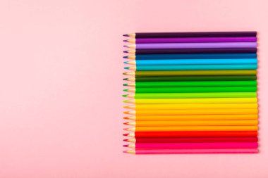 Renkli arka planda renkli kalemler. Boyama için ekipman. Yaratıcılık için kırtasiye malzemesi. Okula dönüyorum. Flatlay. Çocukların Yaratıcılığı ve Eğitimi. Rainbow.Mesaj için yer var. Boşluğu kopyala.