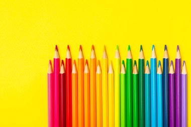 Renkli arka planda renkli kalemler. Boyama için ekipman. Yaratıcılık için kırtasiye malzemesi. Okula dönüyorum. Flatlay. Çocukların Yaratıcılığı ve Eğitimi. Rainbow.Mesaj için yer var. Boşluğu kopyala.