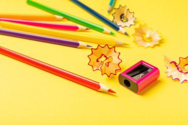 Renkli arka planda kalem açacağı. Kalem ve kalem talaşı. Kırtasiye malzemeleri. Okul malzemeleri. Okul ürünleri. Düz yatıyordu. Mesaj için yer. Boşluğu kopyala.