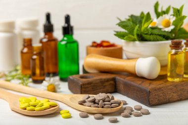 Ahşap zemin üzerinde alternatif ilaç bitkisel kapsül organik ilaç. Bitki ve tablet çeşitleri, vitaminler ve diyet takviyeleri. Sağlıklı yaşam için tıbbi ve şifalı bitkiler.