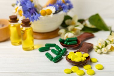 Ahşap zemin üzerinde alternatif ilaç bitkisel kapsül organik ilaç. Bitki ve tablet çeşitleri, vitaminler ve diyet takviyeleri. Sağlıklı yaşam için tıbbi ve şifalı bitkiler.