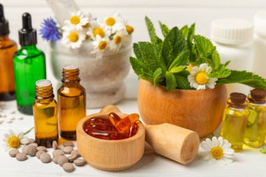 Ahşap zemin üzerinde alternatif ilaç bitkisel kapsül organik ilaç. Bitki ve tablet çeşitleri, vitaminler ve diyet takviyeleri. Sağlıklı yaşam için tıbbi ve şifalı bitkiler.