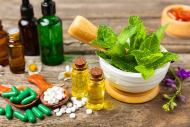 Ahşap zemin üzerinde alternatif ilaç bitkisel kapsül organik ilaç. Bitki ve tablet çeşitleri, vitaminler ve diyet takviyeleri. Sağlıklı yaşam için tıbbi ve şifalı bitkiler.