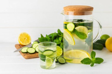 Salatalık suyu, limon, nane ve ahşap bir masada. İçme bardağında dilimlenmiş salatalık ile karıştırılmış su. Tonik ferahlatıcı bir içecek. Salatalık limonata. Doğal soğutma içeceği. Boşluğu kopyala.