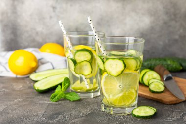 Salatalık suyu, limon, nane ve ahşap bir masada. İçme bardağında dilimlenmiş salatalık ile karıştırılmış su. Tonik ferahlatıcı bir içecek. Salatalık limonata. Doğal soğutma içeceği. Boşluğu kopyala.
