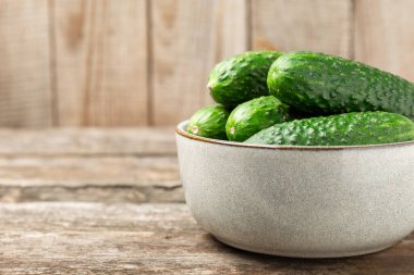 Ahşap arka planda salatalık. Arka planda bir parça salatalık. Taze organik yeşil salatalık turşusu. Vejetaryen. Salata malzemesi. Çiftlik sebzeleri. Sebzeleri bıçakla kes. Mesaj için yer var. Boşluğu kopyala