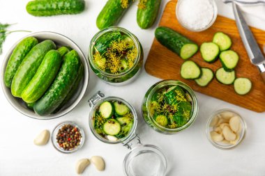 Ahşap bir arka planda kavanozda taze tuzlanmış ev yapımı salatalıklar. Dereotlu, sarımsaklı ve biberli salatalık turşusu. Konserve salatalık, salatalık ve penis. Ev yapımı koruma..