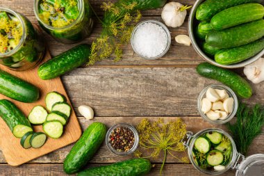 Ahşap bir arka planda kavanozda taze tuzlanmış ev yapımı salatalıklar. Dereotlu, sarımsaklı ve biberli salatalık turşusu. Konserve salatalık, salatalık ve penis. Ev yapımı koruma..