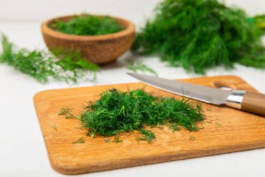 Ahşap arka planda Dill. Taze organik sebzeler. Dill çiftliği. Dereotu yapraklarını kes. Bahar genç deresi sürüsü. Vitaminler. İplik. Aromatik mutfak baharatı. Mesaj için yer. Boşluğu kopyala